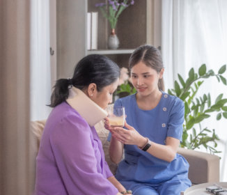 Woman Nurse Helping Mature Woman at Home
