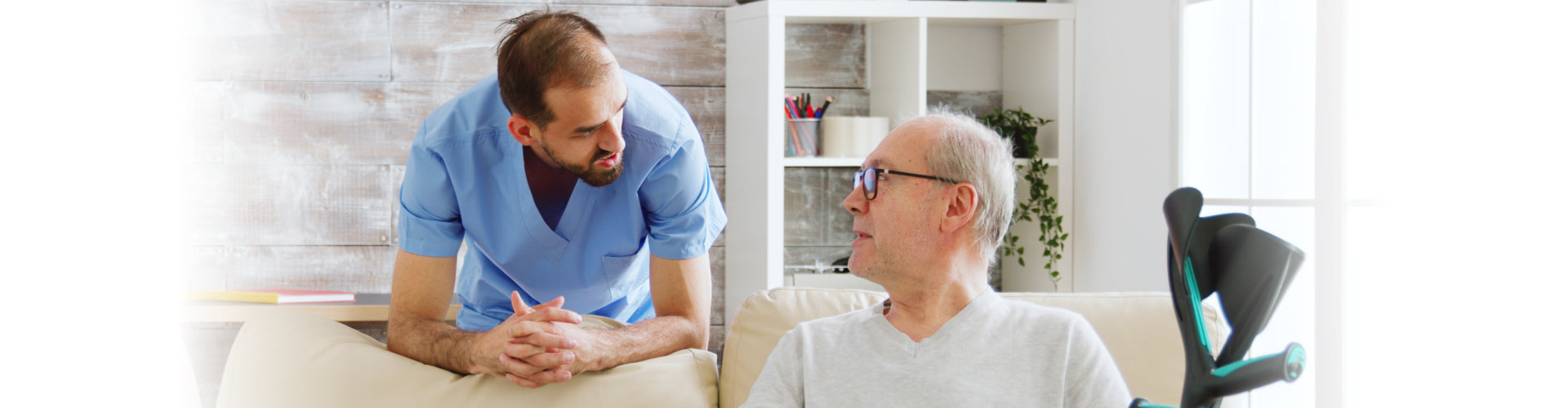 Elderly man having a conversation with a male nurse